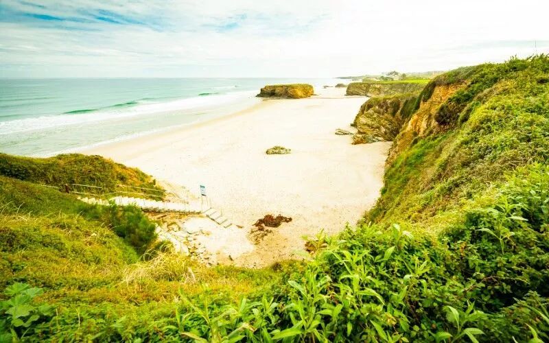 A beautiful beach surrounded by green cliffs