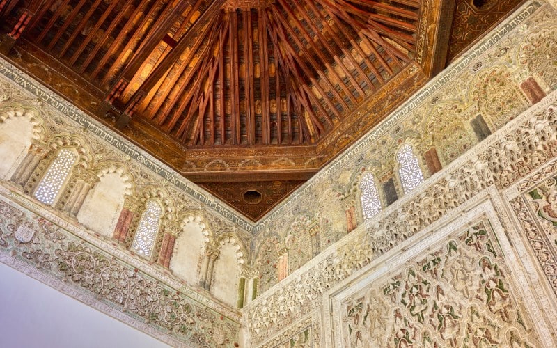 Carved ornamentations on a white wall and a wooden ceiling