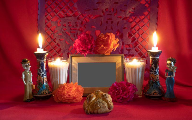 An altar of offerings with candles, food and flowers