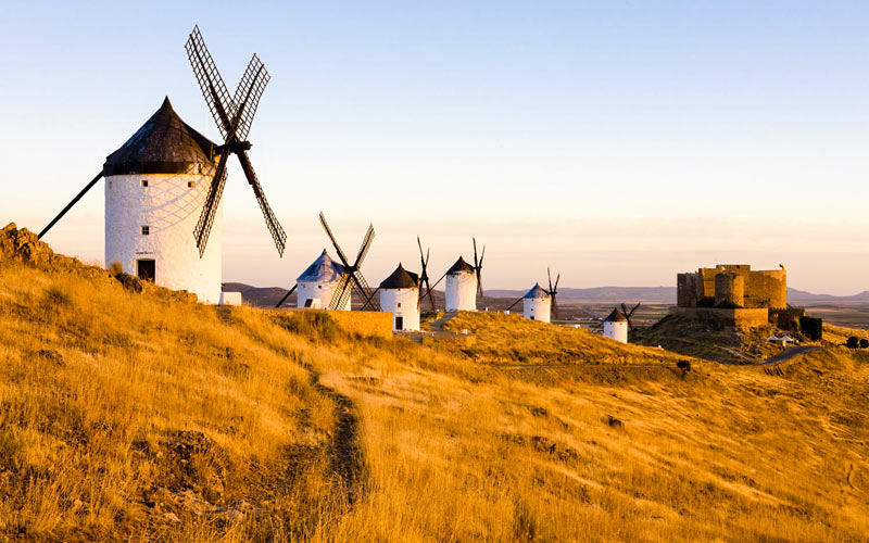 Some windmills in line on a yellow cliff