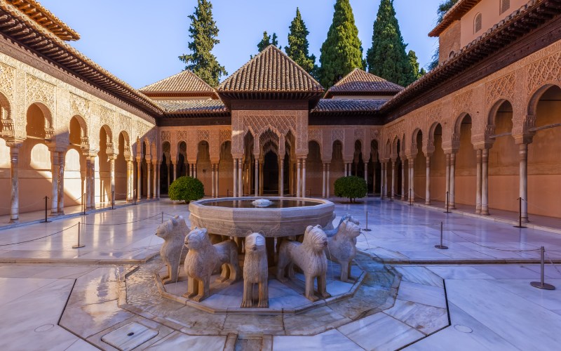 A courtyard with a fountain with lions