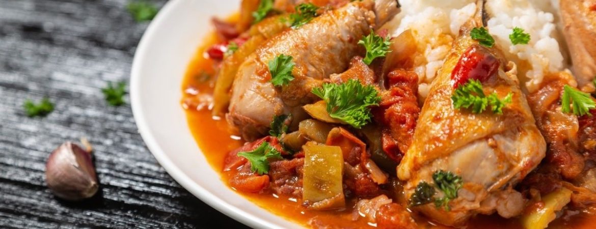 A dish of chicken with tomato sauce and veggies