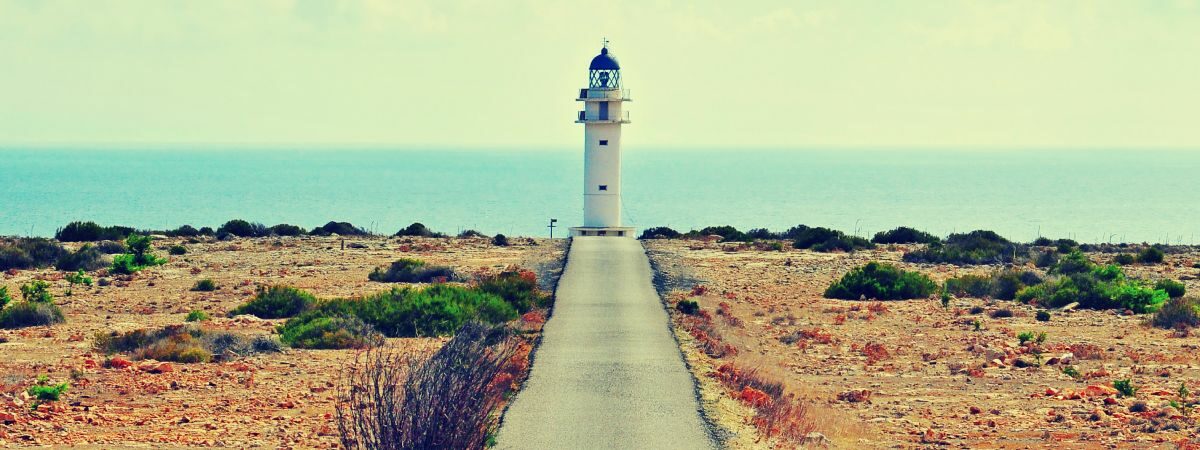 The lighthouse of cape Barbaria, shining at the edge of the Balearic Islands