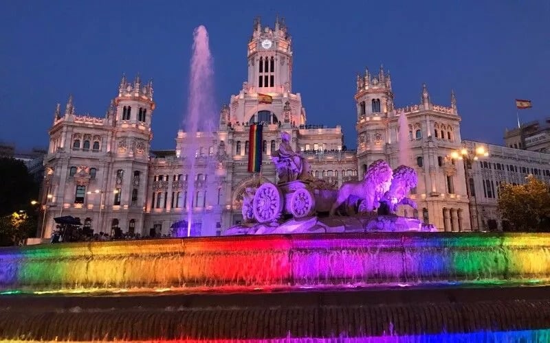 A fountain lit up with rainbow colours