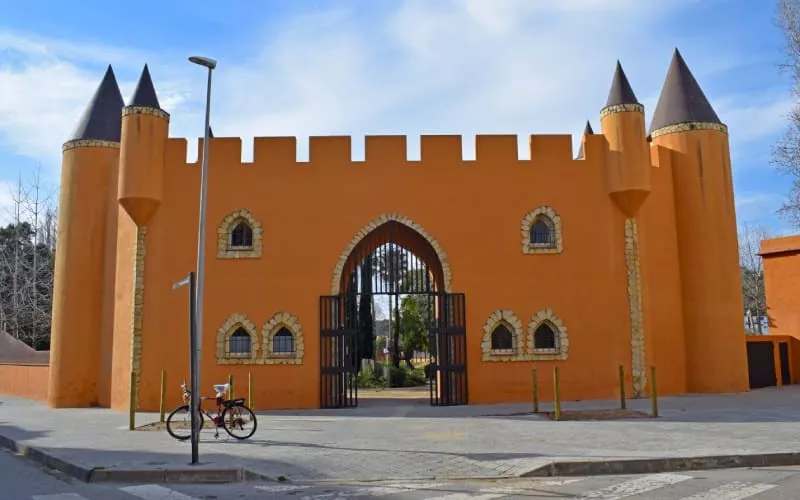 The gate to a park in the shape of an orange castle