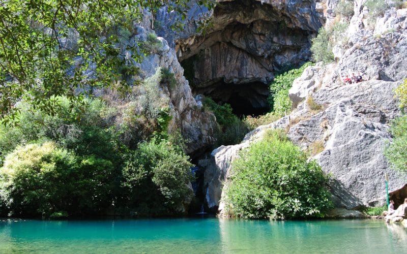 The entry to the cave of Cueva del Gato with a lake in front of it