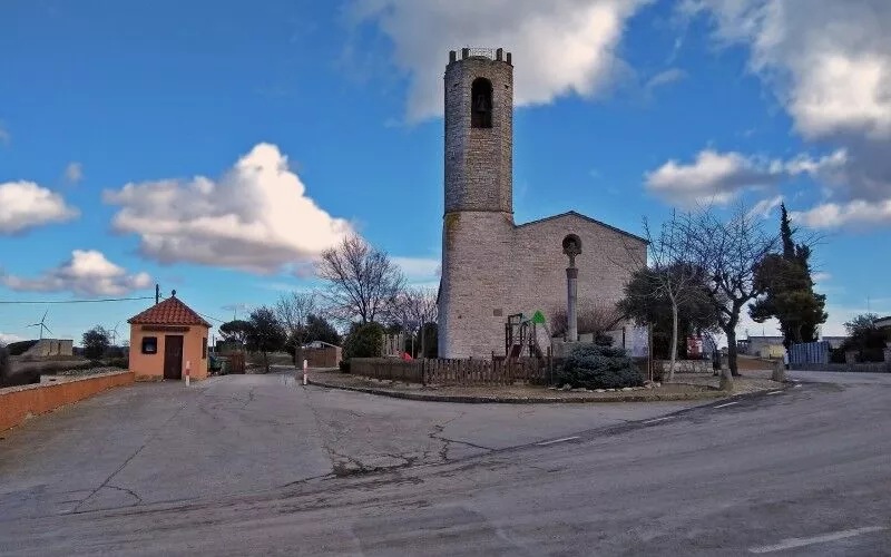 A paved road and a church, with a blue sky