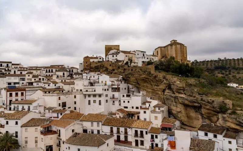Panoramic view of a village of white houses under a rock