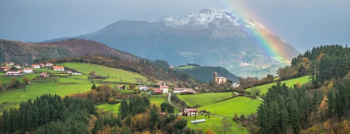 A green valley, mountains and a rainbow